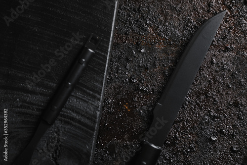 Obraz na płótnie Knife and for on pice of black wood and black texturated background. w salonie