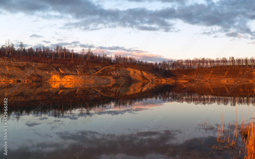 Fototapeta premium Mirror image in the lake of steep banks in spring. Vsevolozhsk. Leningrad region.