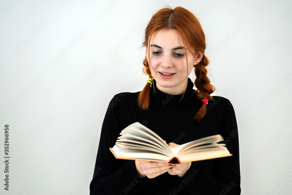 Young pretty girl read an open book in her hands. Reading and education concept. Young pretty girl read an open book in her hands. Reading and education concept.
