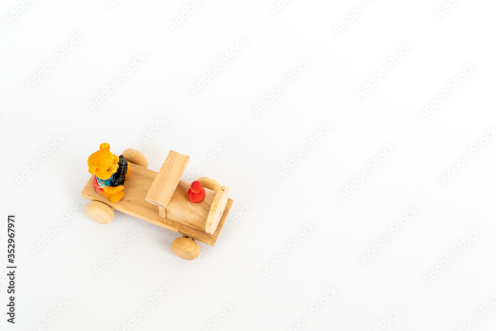 Wooden train on a white background. Wooden toy yellow locomotive with a teddy bear.