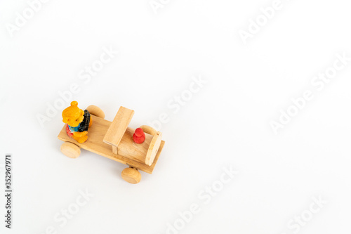 Obraz na płótnie Wooden train on a white background. Wooden toy yellow locomotive with a teddy bear. w salonie