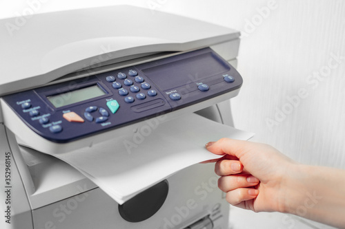 Hand press button on panel of printer. printer scanner laser office copy machine supplies start