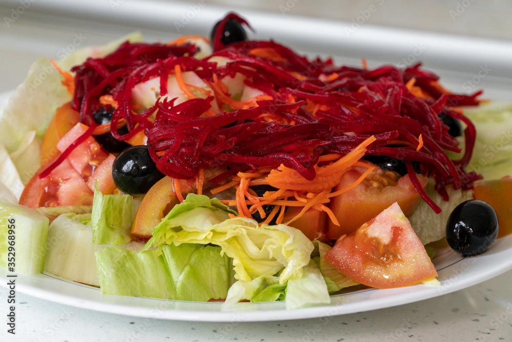 Fresh vegetable salad isolated on white plate