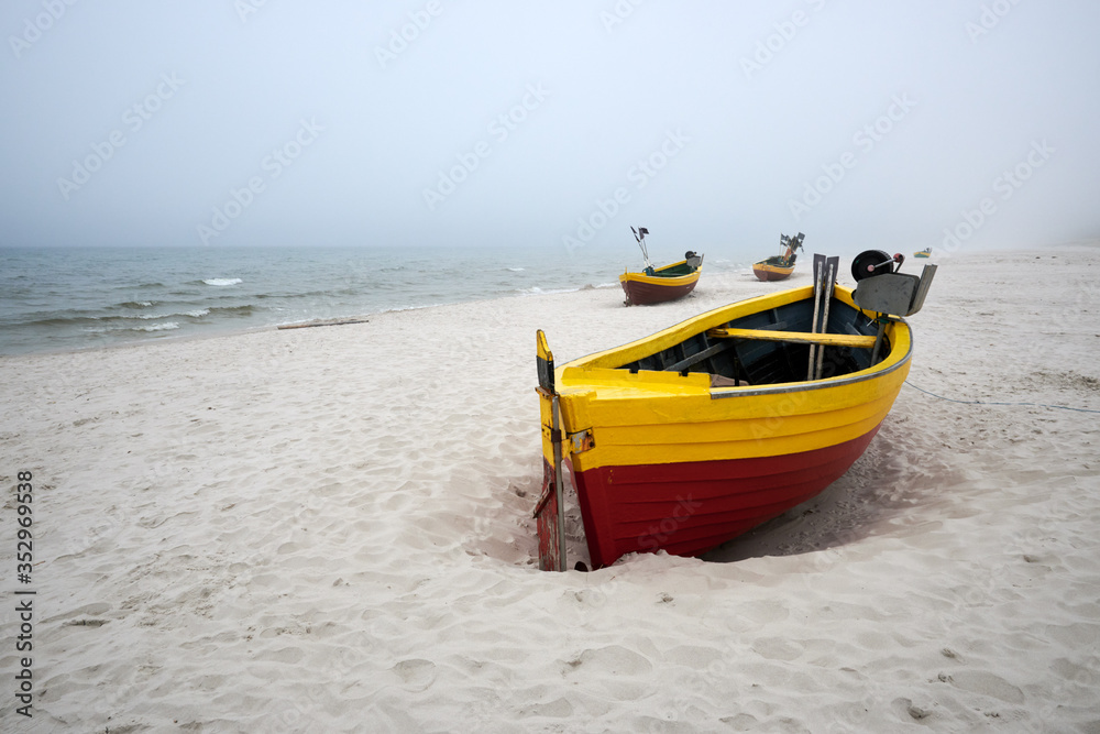 Fishing boats on the beach on a cloudy and foggy day. Baltic Sea, Poland