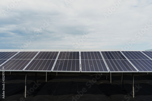 Solar panels stands in row on the ground . Free electricity for home. Sustainability of planet. Green energy. Solar cells power plant business. Ecological clean energy. Blue panels on the ground.