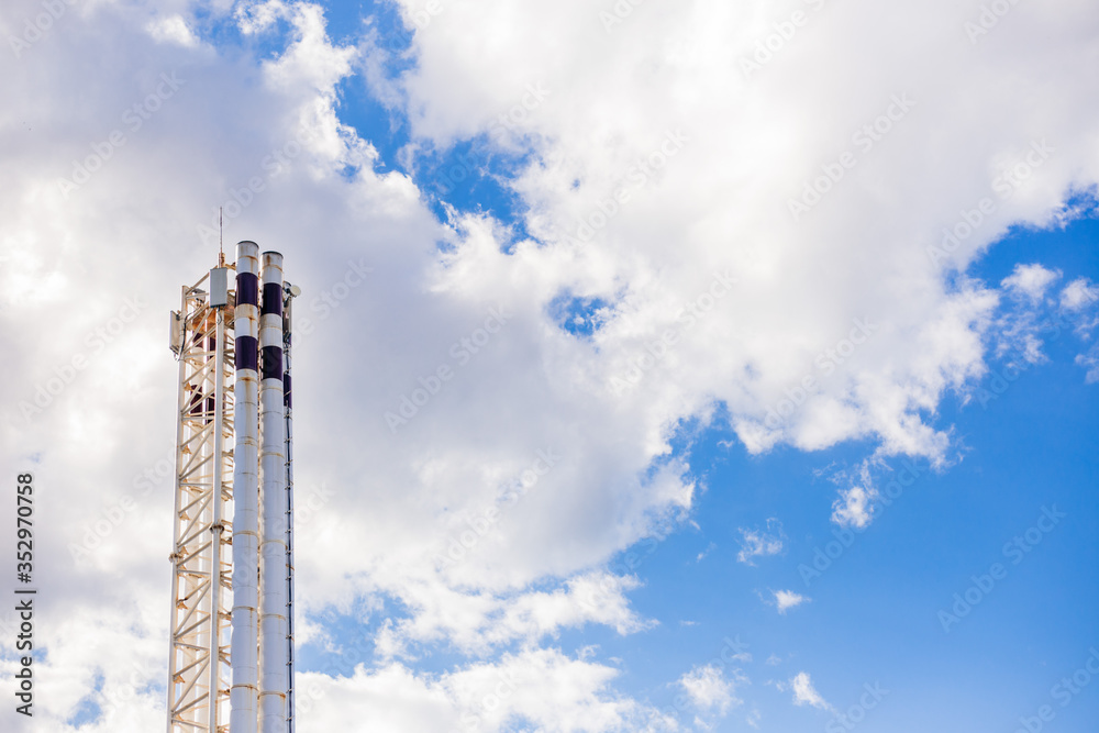 The pipe of a thermal power plant sticks out against the sky. Industrial factory construction. Electricity and heat. The pipe of a thermal power plant sticks out against the sky. Industrial factory construction. Electricity and heat.