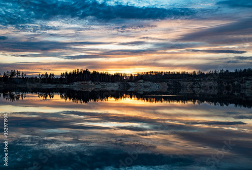 Mirror image of the sunset on the lake in spring. © amarinchenko106