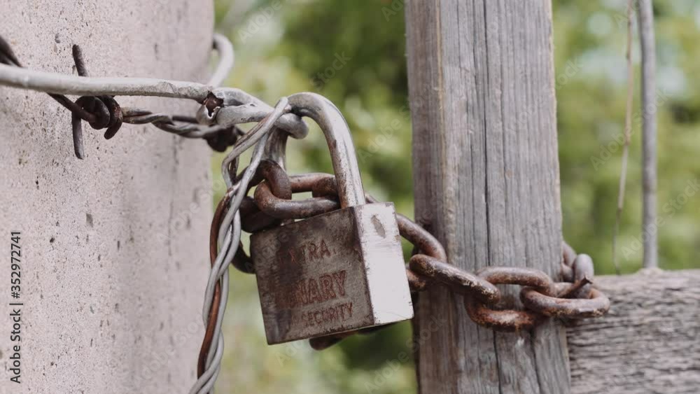 old lock on a rusty chain. A man's hand yanks him to make sure it's closed old lock on a rusty chain. A man's hand yanks him to make sure it's closed