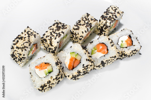 Japanese roll of rice, sesame seeds, cream cheese, cucumber, salmon on a white background