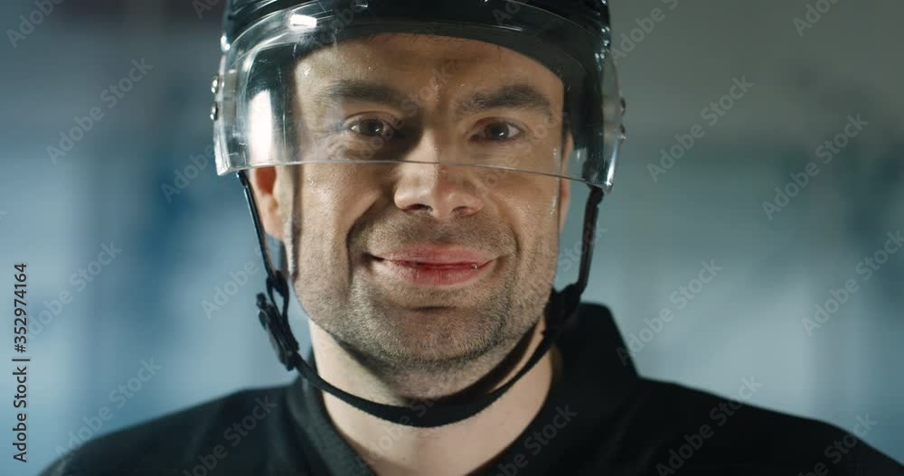 Close up of happy handsome young Caucasian male hockey player in helmet smiling cheerfully on ice arena. Portrait shot of joyful good looking professional sportsman. Close up of happy handsome young Caucasian male hockey player in helmet smiling cheerfully on ice arena. Portrait shot of joyful good looking professional sportsman.