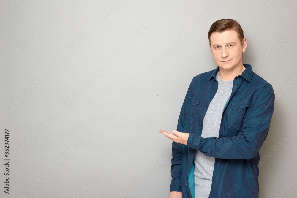 Portrait of happy man pointing with hand at copy space and smiling Portrait of happy man pointing with hand at copy space and smiling