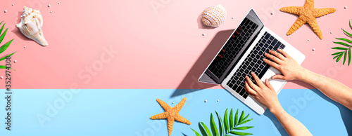 Photography Person using a laptop computer with summer theme objects - flat lay