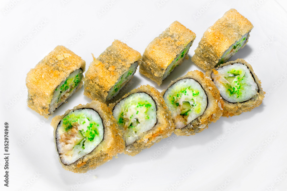 Japanese tai tempura roll made from traditional ingredients of rice, perch, cucumber, tobik, cream cheese on a white plate