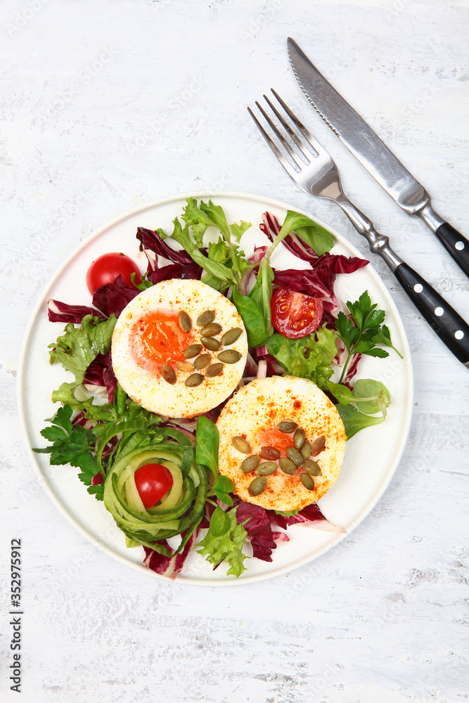 Fried eggs with pumpkin seeds and lettuce. Photo on a light background. Copy of the space.Top view.