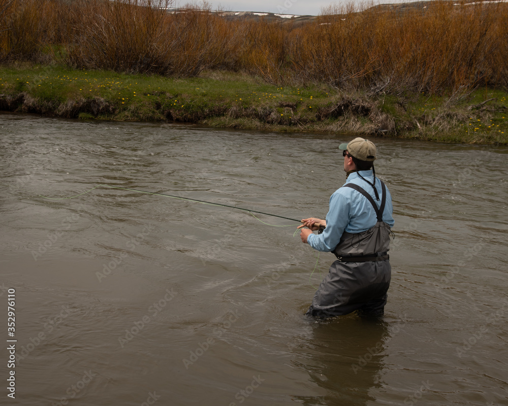 A man teaching a boy how to fly fish on a western trout stream. A man teaching a boy how to fly fish on a western trout stream.