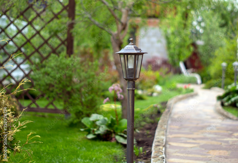 Lamp for the garden on the background of grass and trees Lamp for the garden on the background of grass and trees