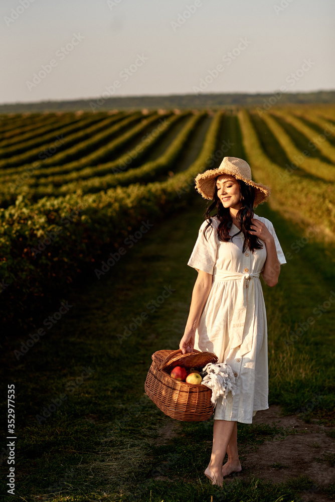 Obraz premium Woman holding fruit basket in front of currant field.