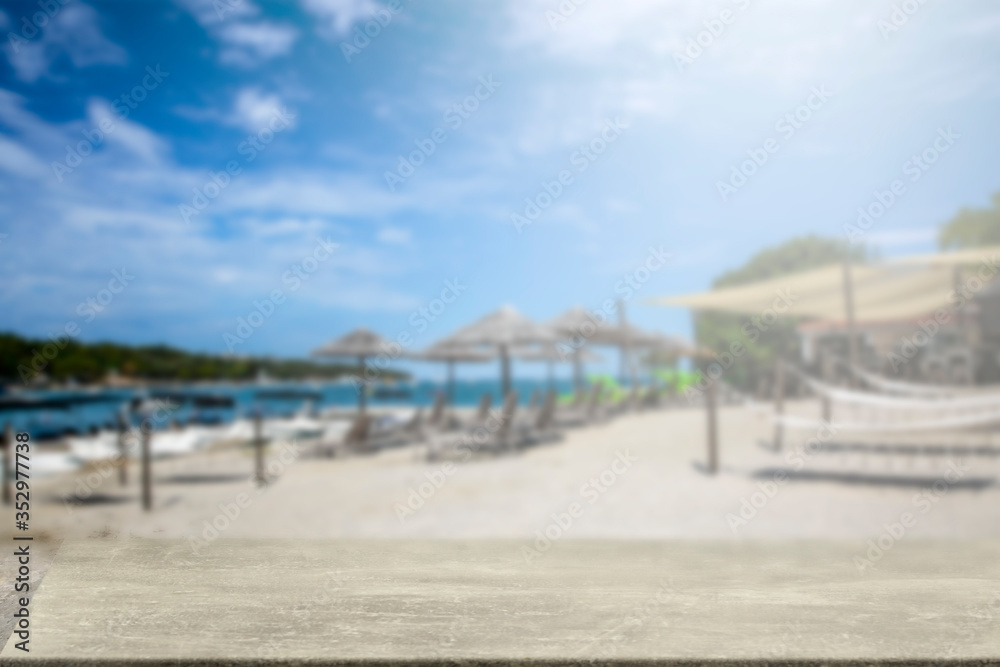 Fototapeta premium Wooden table on the seafront among umbrellas and holiday sun