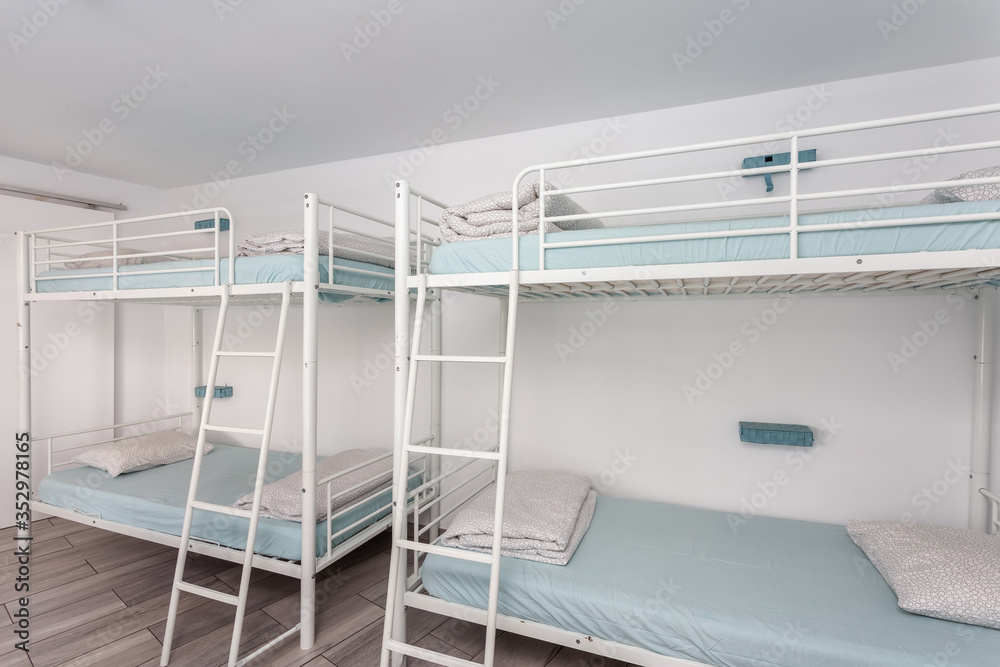 Clean bedroom with bunk beds in a hotel, a hostel for tourists. - obrazy, fototapety, plakaty 