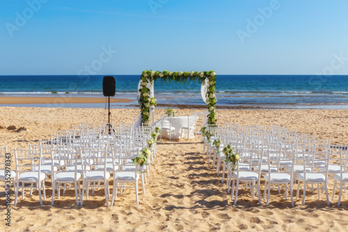 Romantic view and flower decorations on the beach near the sea  for a wedding ceremony with flowers. Europe  Portugal.