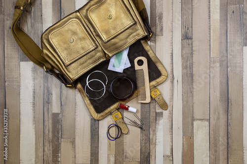 The golden bag and and its content on the wooden floor