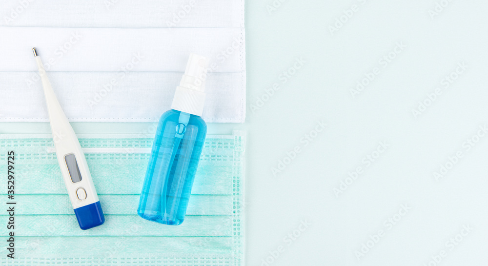 Thermometer temperature, blue alcohol spray, white cotton mask, medical blue mask with light blue texture background, Top view, Flat lay design, Copy space, covid-19 and flu protection concept 