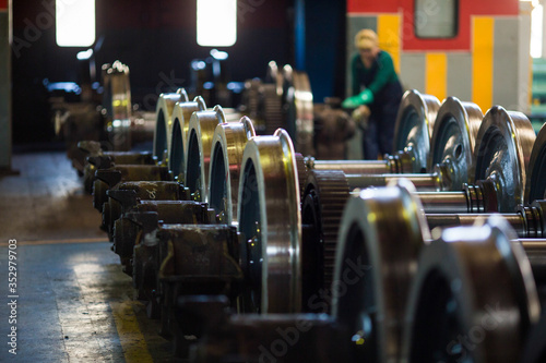 Axles with wheels of railway cars lie in a row at a repair plant