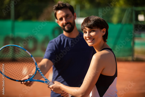 woman learning to play tennis with a tennis teacher © kevin