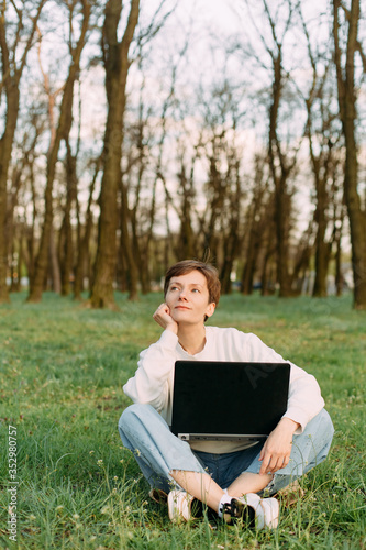 woman emotion laptop sits grass meadow forest