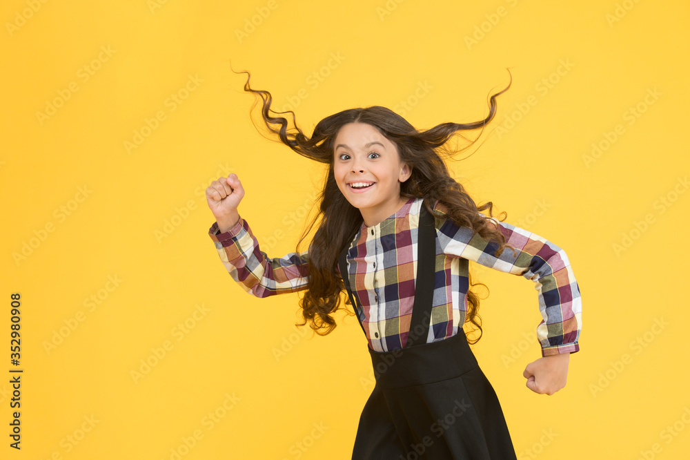 Make haste slowly. Energetic girl hurry to school. Small child wear long hairstyle yellow background. Back to school hairstyle. Hair salon. Fashion hairstyle. School look. Great hairstyle every day Make haste slowly. Energetic girl hurry to school. Small child wear long hairstyle yellow background. Back to school hairstyle. Hair salon. Fashion hairstyle. School look. Great hairstyle every day