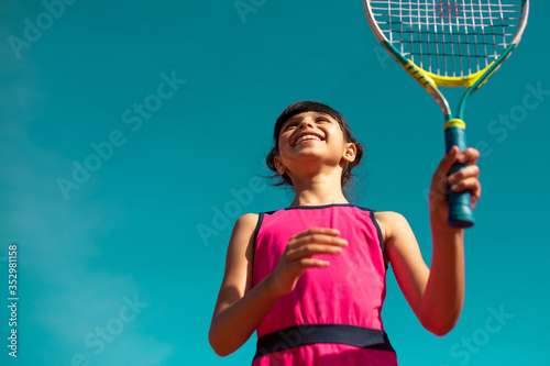 petite fille jouant au tennis sous un ciel bleu © kevin