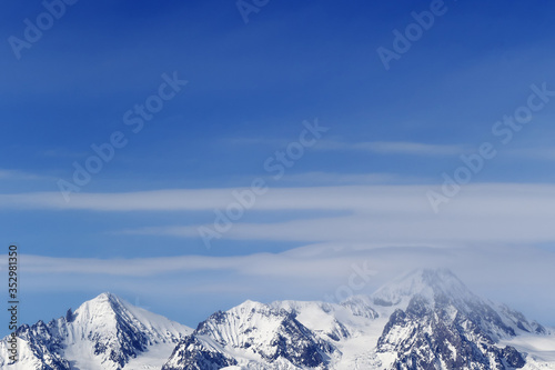 High snowy mountains and blue sky with clouds