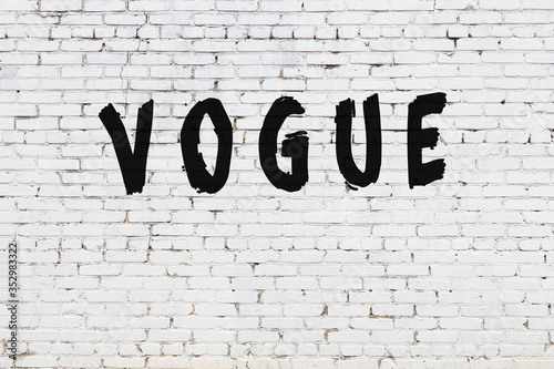 Word vogue painted on white brick wall photo