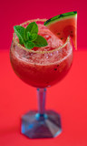 Watermelon cocktail on red background. Fresh watermelon with mint and ice for summer party. Refreshing.