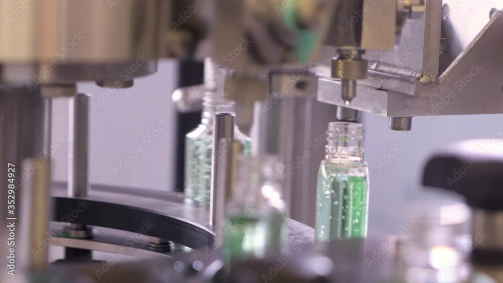 Plastic bottles for sanitizers gel are moving along the conveyor belt at the factory for the production of personal protective equipment.