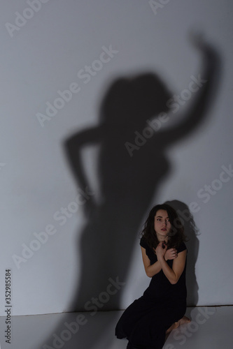 Young woman and shadow on the wall photo