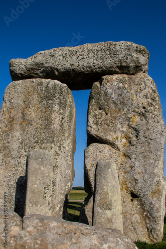 Standing rocks at Stonehenge with lintel rock on top and two smaller rocks inside the circle - taken from inside with very blue sky photo