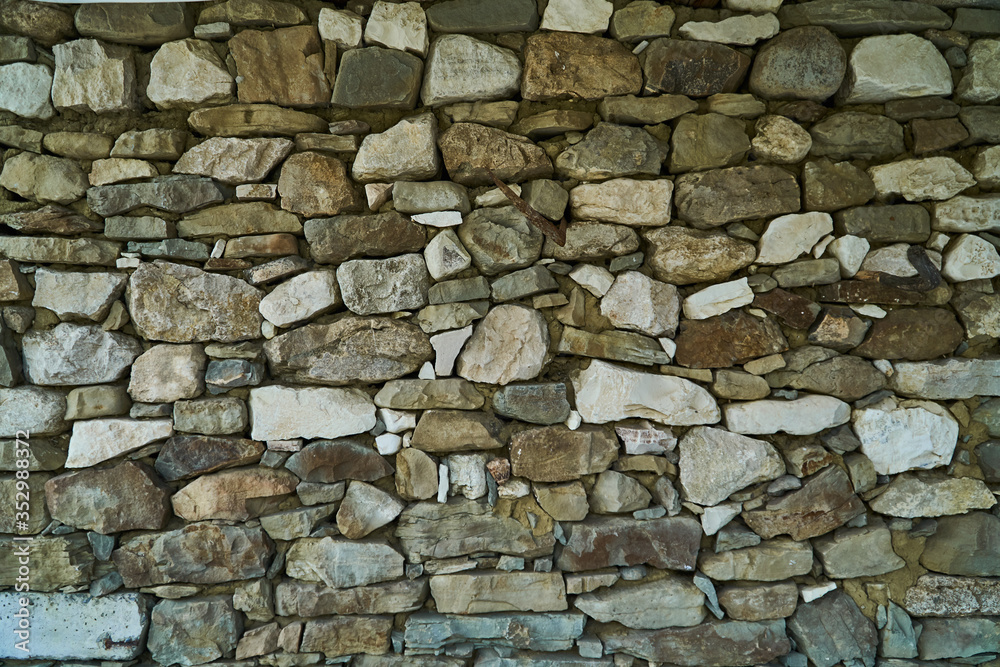 Fototapeta premium The texture of the stones. The stone splits. Rocks in the section. Tiles and mountains. The Wallpaper is grey.