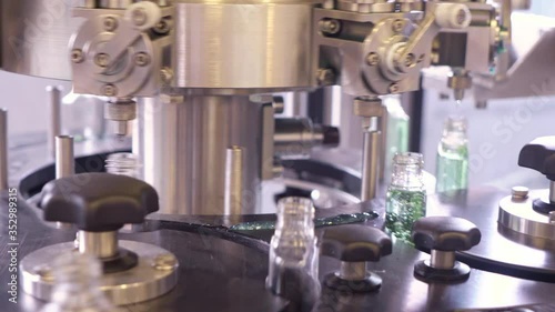 Plastic bottles for sanitizers gel are moving along the conveyor belt at the factory for the production of personal protective equipment.