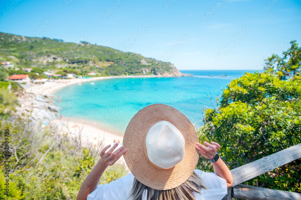 Female with straw beach hat on mediterranean sea coast background. Summertime banner. Meditation and relax. Vacation and tourism concept.