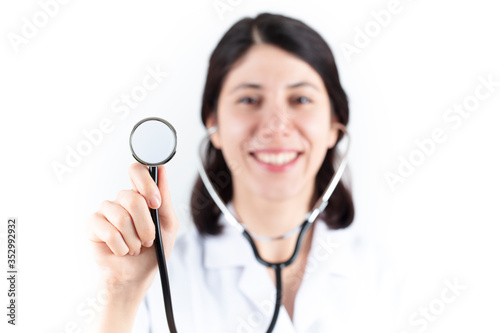 Young female doctor and stethoscope isolated in white background. heart health and medical concept.