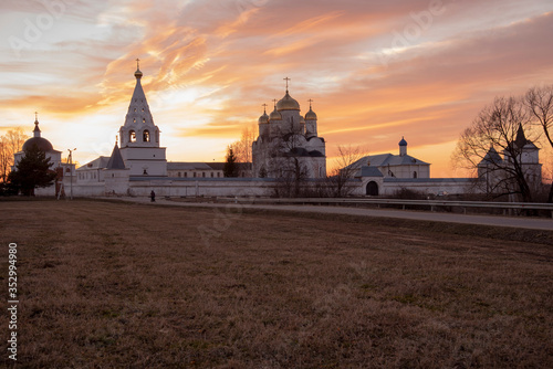 White stone wall and towers of the monastery against the background of the evening sky.