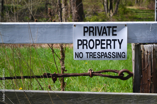 Sign on wooden fence stating 'Private Property No Trespassing. Close up.