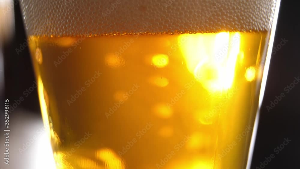 carbonated drink in a yellow-gold glass, bubbles slowly rise, closeup carbonated drink in a yellow-gold glass, bubbles slowly rise, closeup