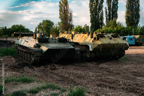 Old Russian armored vehicles on sunset background at military base