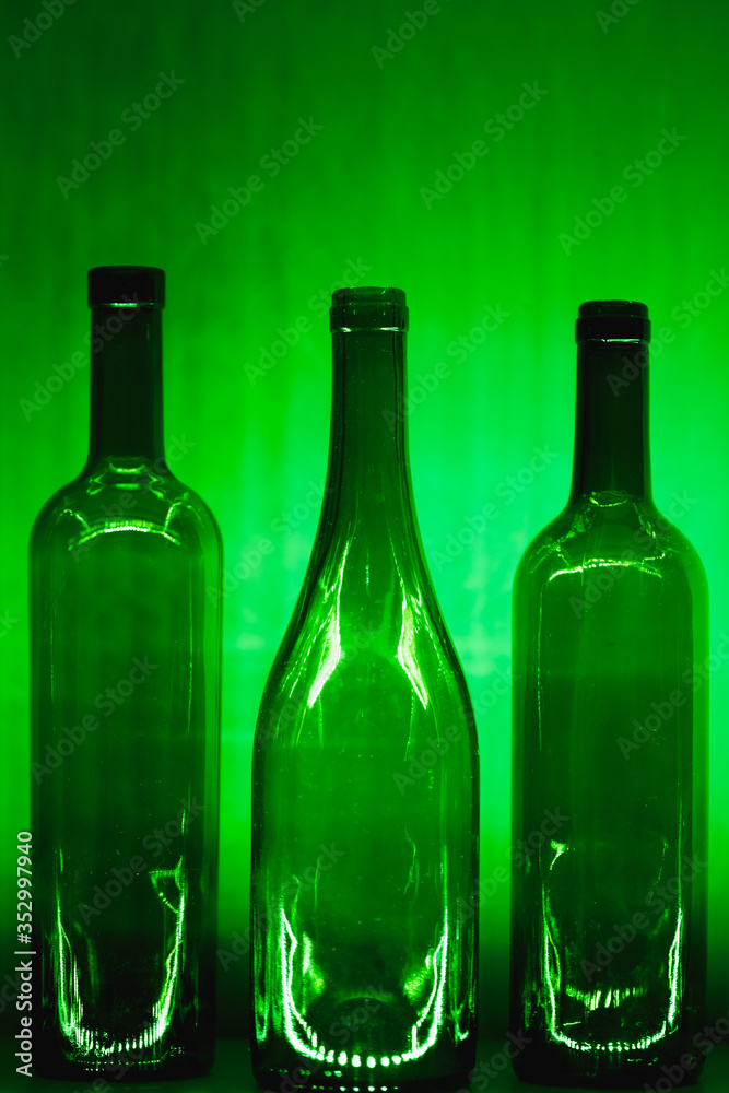 abstract empty wine bottles with green illumination abstract empty wine bottles with green illumination