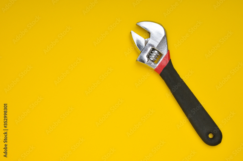 Adjustable wrench on yellow background Adjustable wrench on yellow background