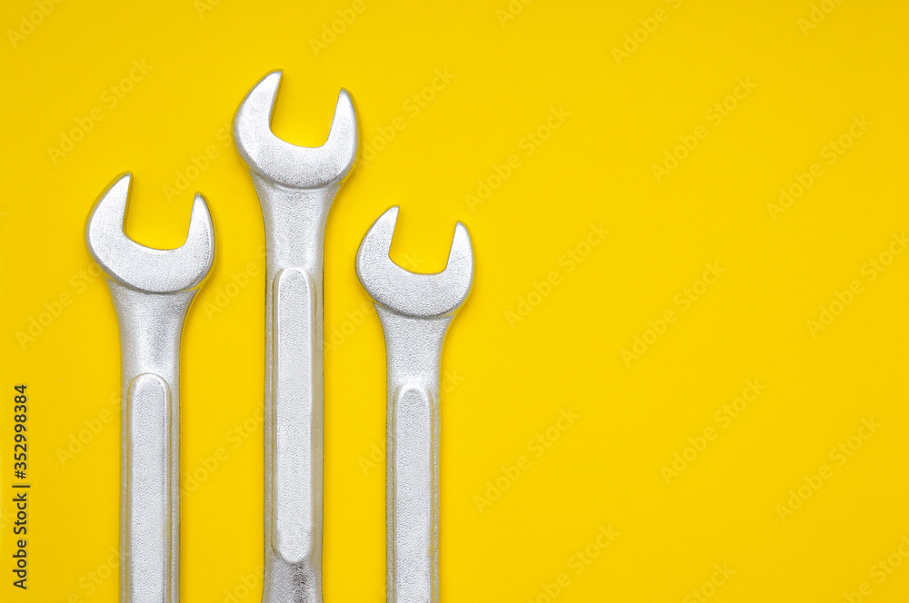 Three wrenches on a yellow background Three wrenches on a yellow background
