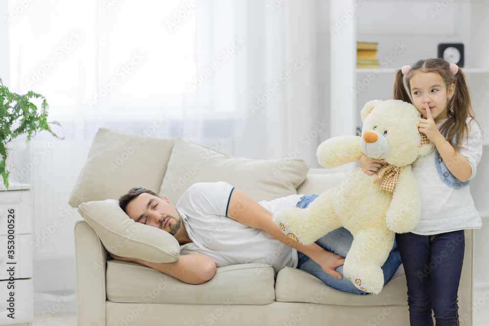 Father is sleeping and his daughter holds a white bear. Father is sleeping and his daughter holds a white bear.