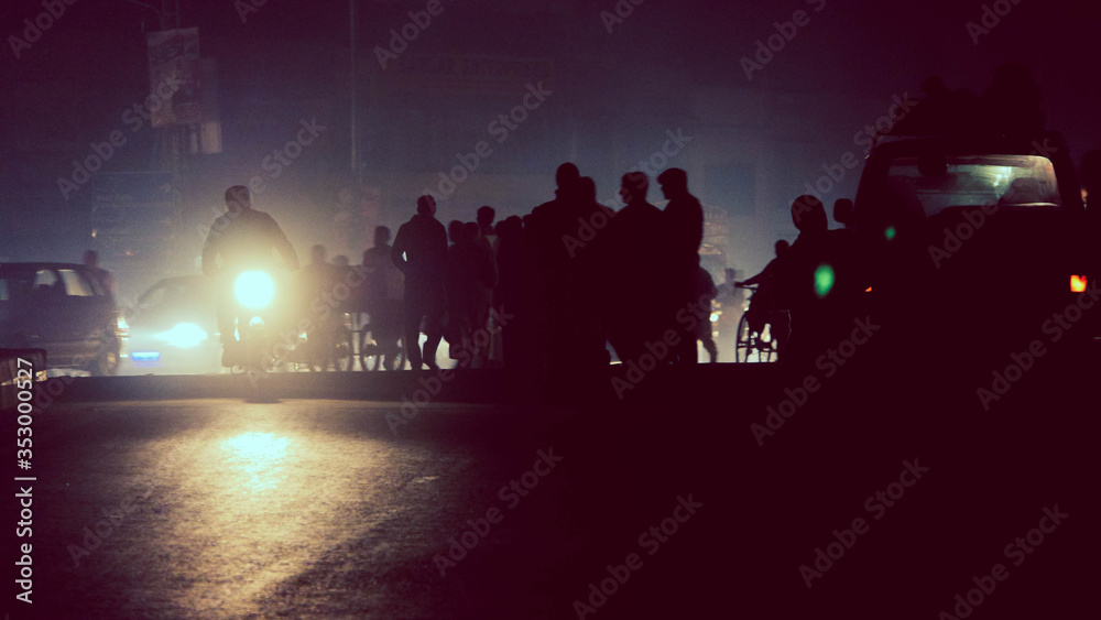 Silhouette of crowds and motorcycle headlights